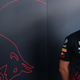 Max Verstappen smiles in front of a Red Bull logo